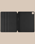 a black ipad case is open on a beige background